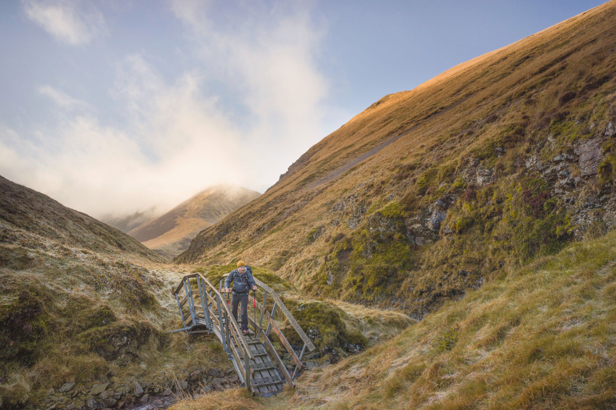 Hiker crossing a wooden bridge.