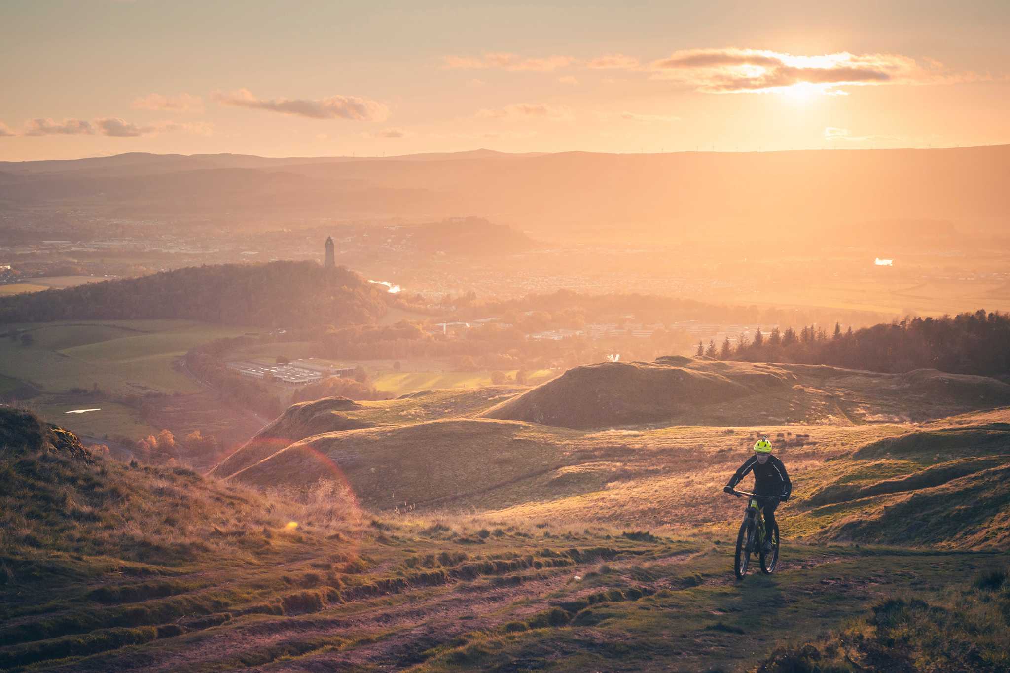Cyclist on hillside at sunrise