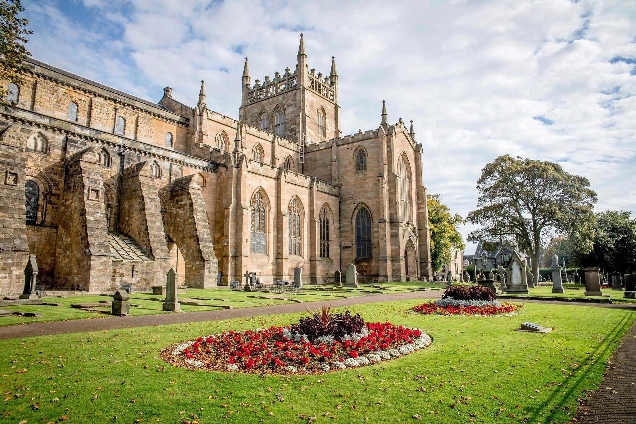 Historical Abbey building with floor beds in the foreground