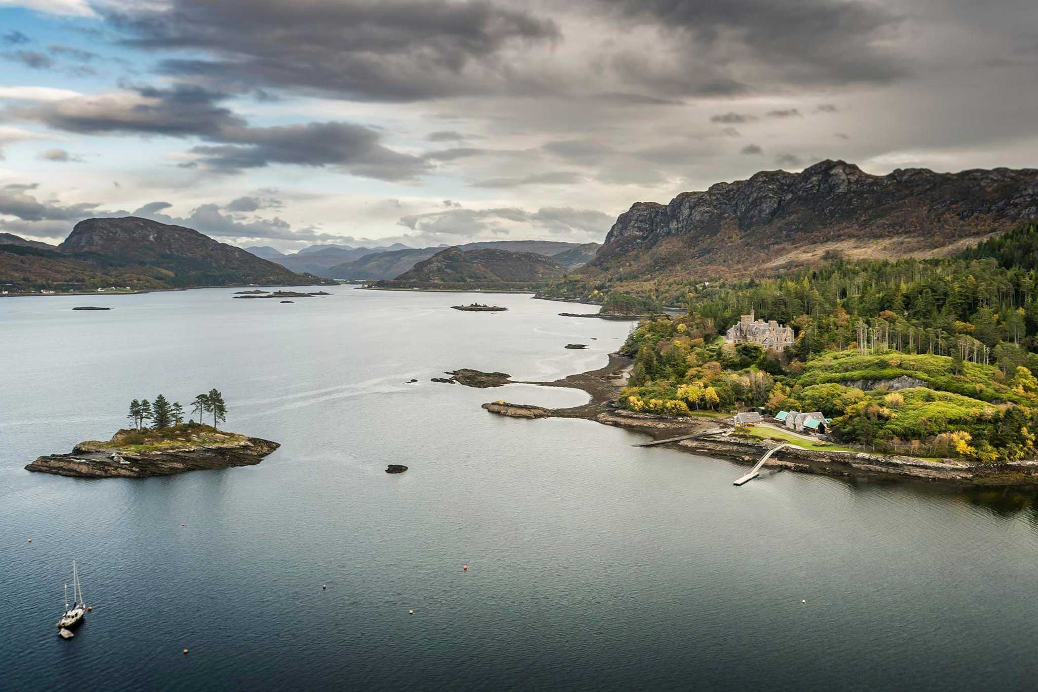 Ariel image of Plockton harbour with island and a boat just off the coastline