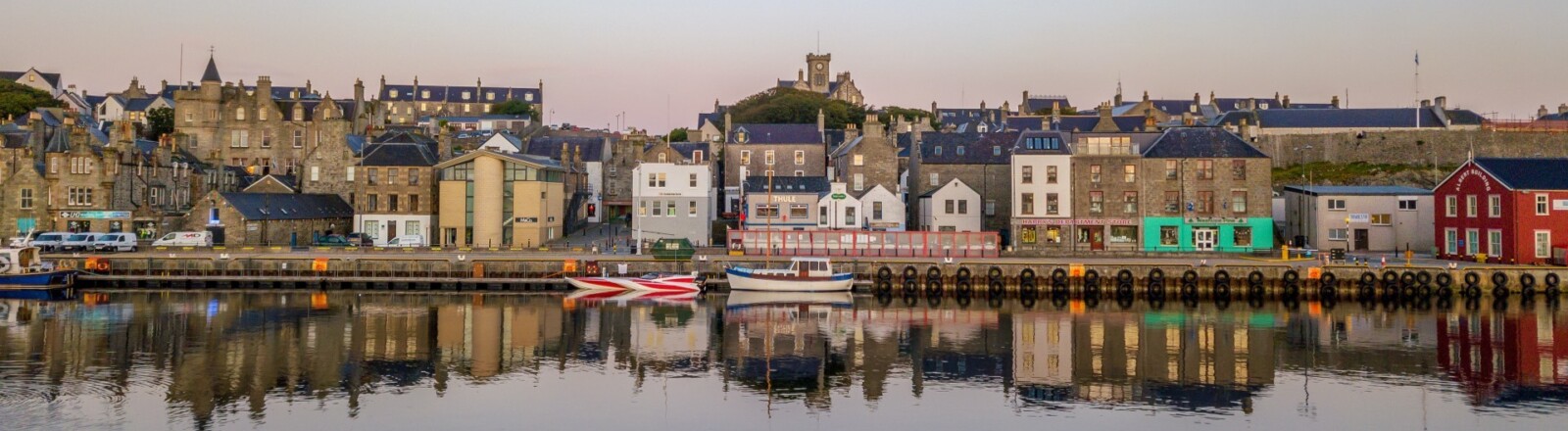 The buildings along Lerwick harbour, the light fading against the water