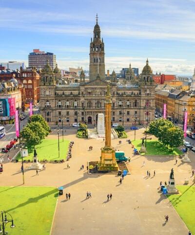 Luftaufnahme von George Square in Glasgow, umgeben von Rasenflächen und Gebäuden.