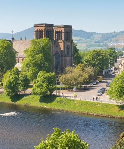 Looking across the River Ness to Inverness Cathedral, surrounded by green trees