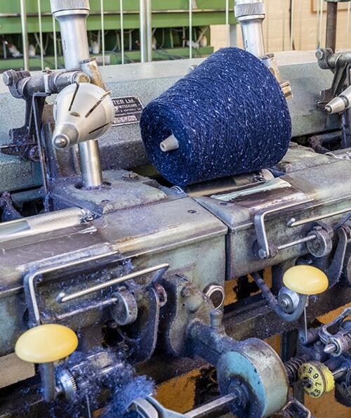 A cone of navy blue yarn sitting on top of machinery at New Lanark
