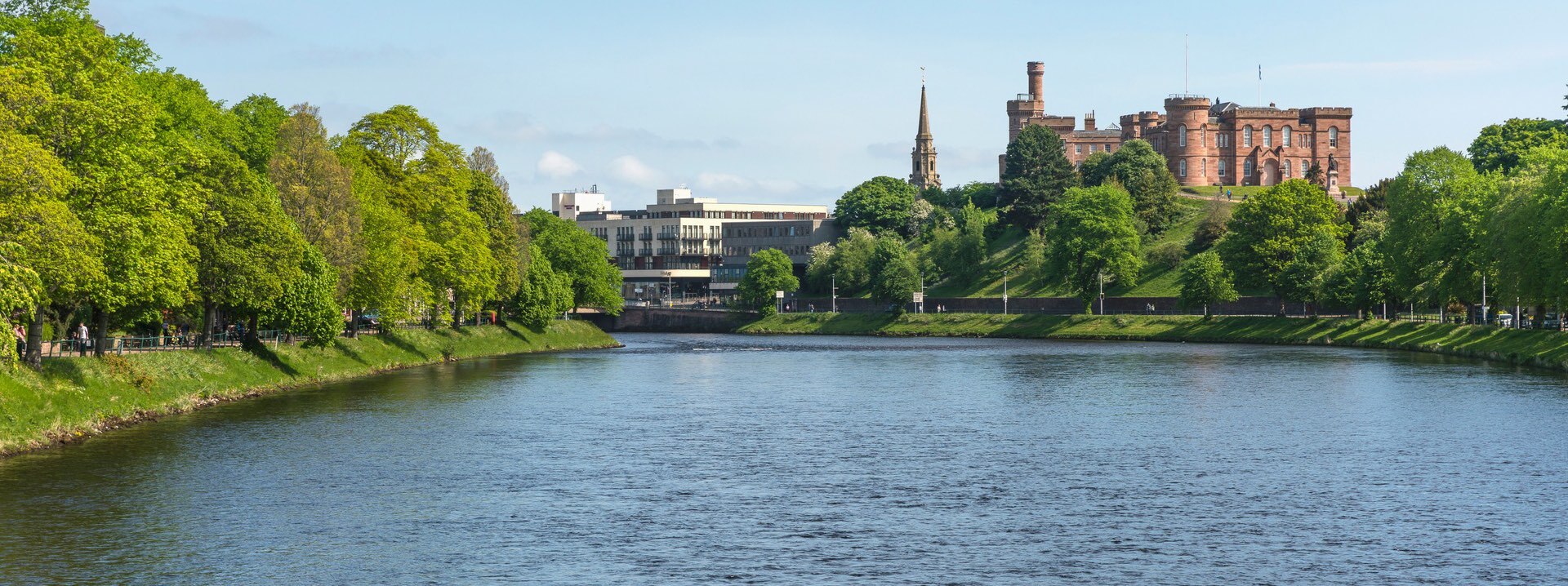 Looking over the River Ness to the buildings of Inverness behind, trees on either side