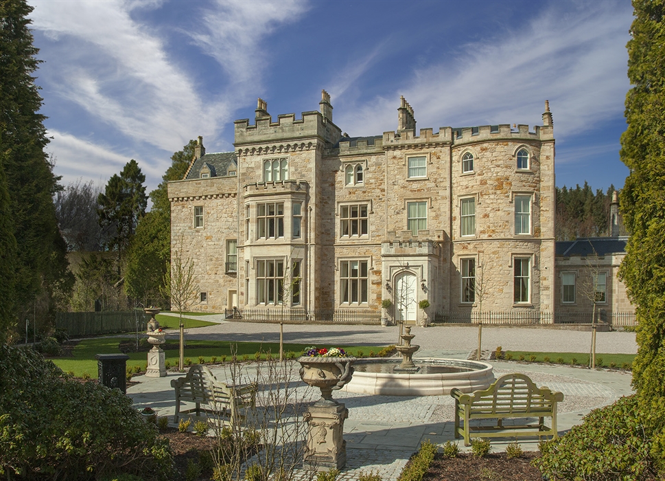 An exterior shot of the 17th century castle, with a fountain in the foreground 